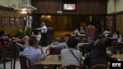 Un grupo de personas en un bar en el centro de Belo Horizonte (Brasil) observa la transmisión del mensaje de la presidenta brasileña, Dilma Roussef.