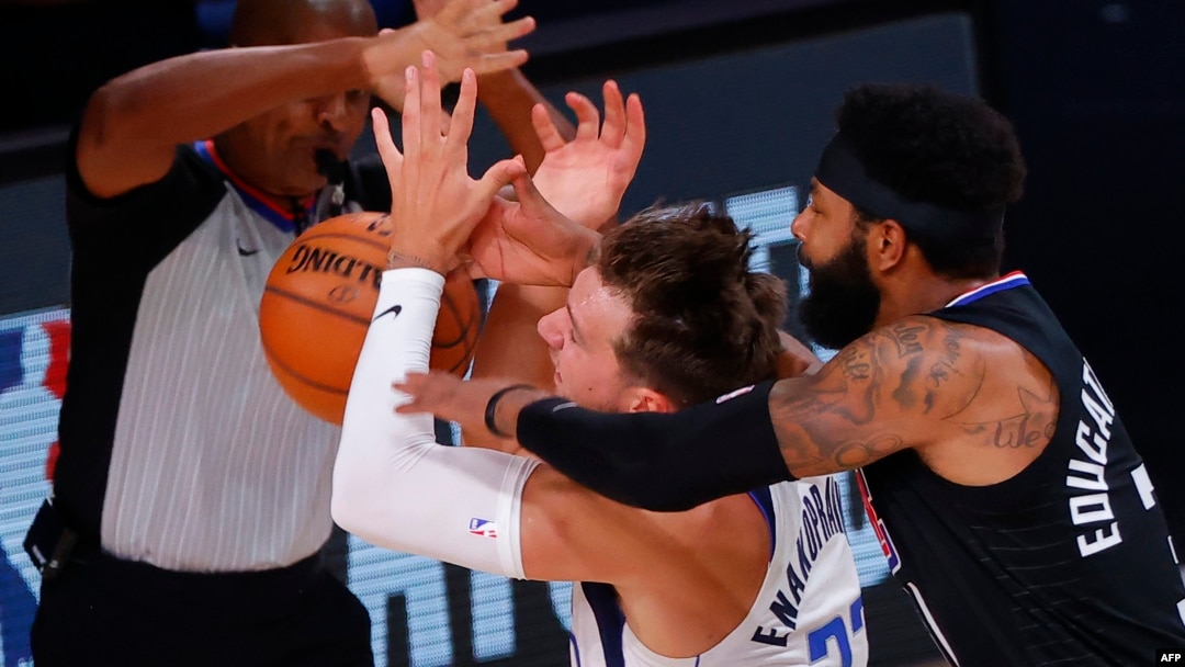 Marcus Morris Sr., (R) de LA Clippers, Luka Doncic (C) del Dallas Mavericks durante NBA Playoffs 2020 en Lago Buenavista, Florida.