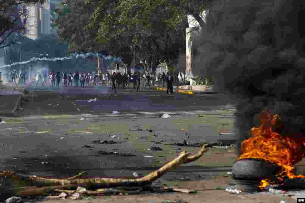 Un grupo de manifestantes se defienden de la policía durante una protesta