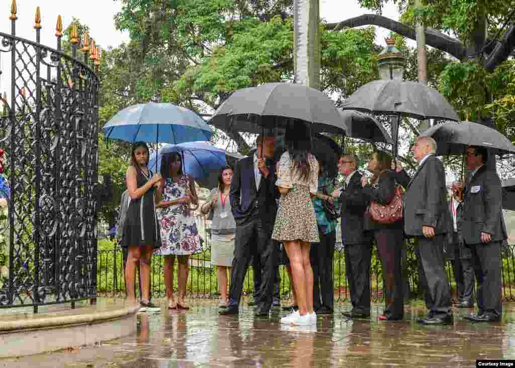 Obama recorre La Habana Vieja con paraguas. 