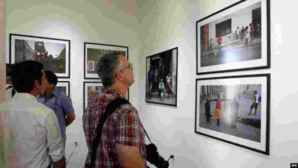 Varias personas observan imágenes de la fotógrafa colombiana Eliana Aponte