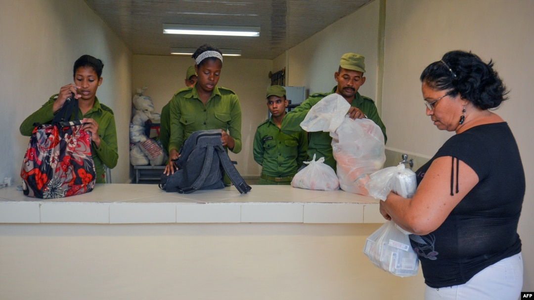 Oficiales del MININT revisan los bolsos a una mujer que visita una cárcel en Cuba. Foto Archivo