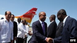 El primer ministro de Haití, Laurent Salvador Lamothe (c), saluda a varios oficiales cubanos acompañado por el vicecanciller de Cuba, Rogelio Sierra (i), a su llegada al aeropuerto habanero "José Martí" de La Habana (Cuba)