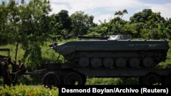 Soldados de las Fuerzas Armadas Revolucionarias Cubanas (FAR) descansan junto a un tanque cargado en un camión durante ejercicios militares de rutina.