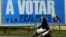 Una mujer pasa frente a un cartel alusivo a las elecciones municipales en Cuba. (Archivo)