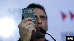El líder de la oposición venezolana y actual gobernador del estado Miranda, Henrique Capriles, sostiene la Constitución del país durante una rueda de prensa, al conocer la decisión del Tribunal Supremo de Justicia respecto a Chávez.