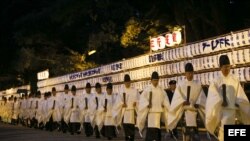 Varios sacerdotes sintoístas abandonan la sala de adoración y dejan atrás la puerta sur tras finalizar un ritual sintoísta de preparación para la llegada del Año Nuevo 2013 en el templo Meiji de Tokio (Japón). 