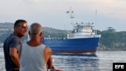 Dos pescadores en La Habana observan el barco estadounidense "Ana Cecilia", que zarpó desde Miami.