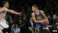 El cubanoamericano Brook López intenta detener a Stephen Curry.