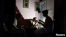 Una familia juega a las cartas mientras usa una lámpara recargable para iluminar su casa durante un corte de energía en Bejucal, provincia de Mayabeque, Cuba, 8 de febrero de 2024. REUTERS/Norlys Pérez