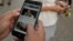 Cubanos usan sus teléfonos celulares para conectarse a internet. (YAMIL LAGE / AFP)