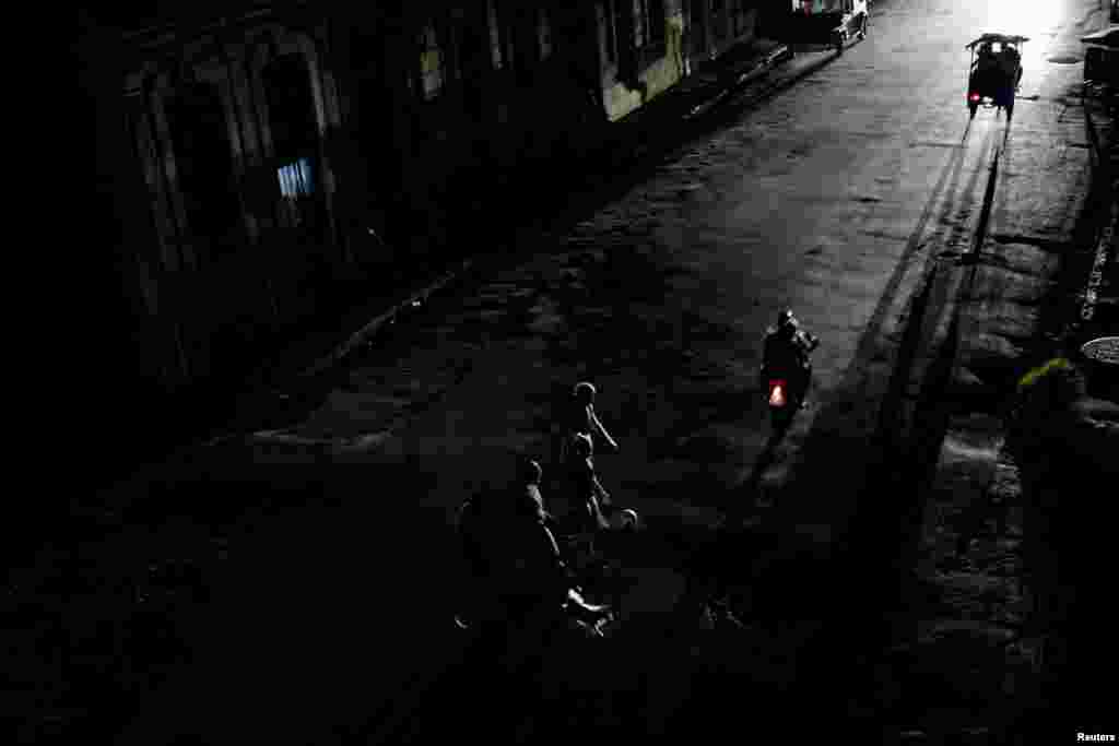 Personas cruzan una calle mientras colapsa la red eléctrica nacional de Cuba —el tercer apagón importante en nueve días— en La Habana, Cuba, el 14 de julio de 2026. REUTERS/Norlys Perez