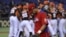 El jugador cubano Jose Abreu pasa delante del equipo holandés, que se encuentra celebrando su victoria tras imponerse a Cuba en el Clásico Mundial de Béisbol disputado en el estadio Tokyo (Japón). 