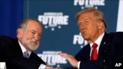 Trump habla con el exgobernador de Arkansas, Mike Huckabee, en una mesa redonda en el Drexelbrook Catering & Event Center, en octubre pasado, en Drexel Hill, Pensilvania. (AP/Julia Demaree Nikhinson)