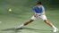 El tenista serbio Novak Djokovic devuelve la bola.