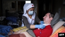 Enfermera en Rusia atiende a un paciente de COVID-19