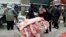 Un vendedor carga una carretilla con carne de cerdo para vender en un mercado de Shenyang, China.
