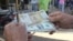 Un hombre muestra un peso convertible cubano y un dólar estadounidense. (Archivo)