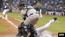 El jugador de Tampa Bay Matt Joyce (L) se desliza en el home frente al receptor de los Yankees de New York Austin Romine (R). Archivo.