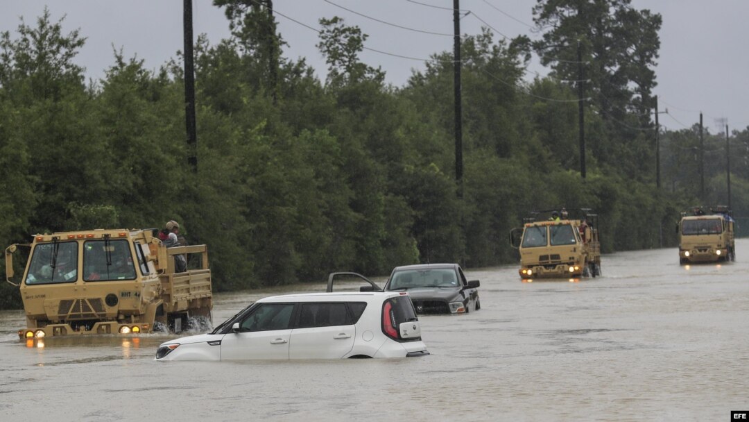 Camiones de la Guardia Nacional de Texas que llevan a víctimas de inundaciones pasan junto a vehículos sumergidos después del paso del huracán Harvey en Houston, Texas, Estados Unidos, 29 de agosto de 2017. El huracán Harvey llegó a tierra en la costa sur