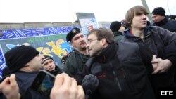 Manifestantes protestan mientras desmantelan una sección del muro de Berlín en Alemania. 
