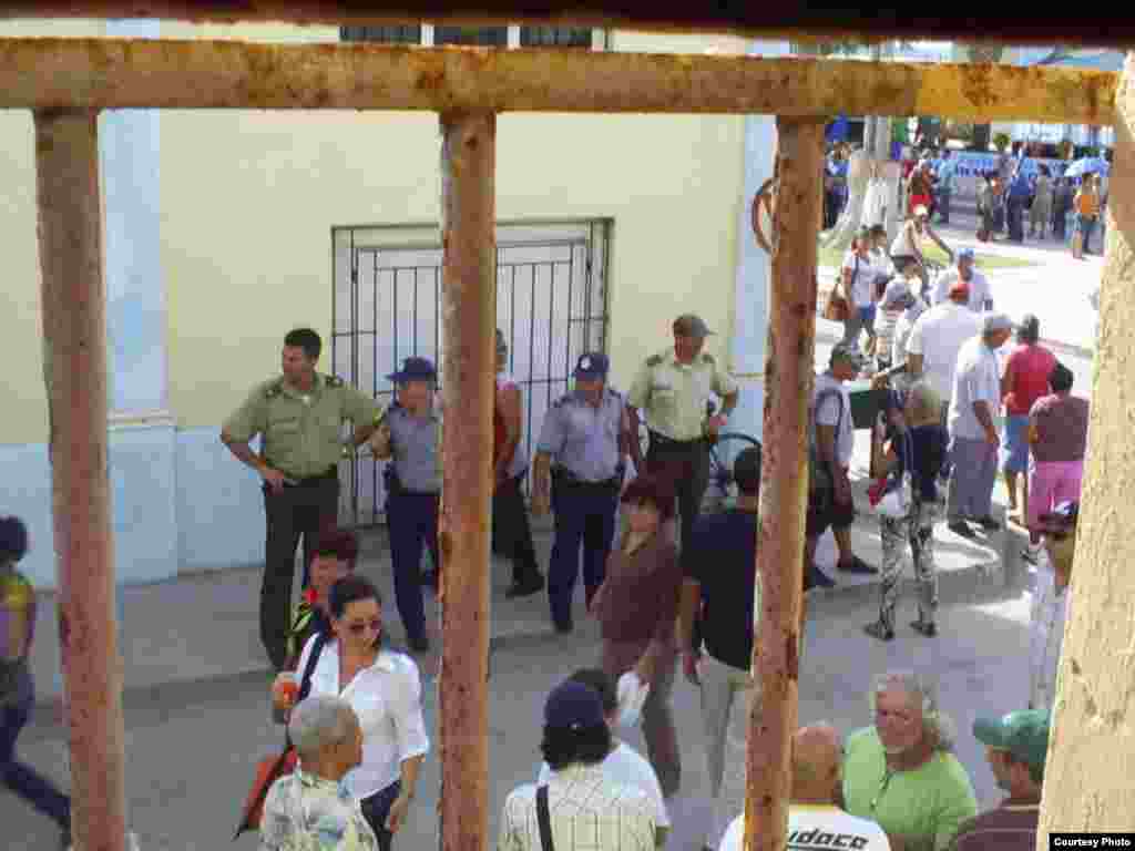 Oficial de la Policía Nacional Revolucionaria (PNR) y otras fuerzas del Ministerio del Interior (MININT) cerca vivienda de opositores en Holguín.