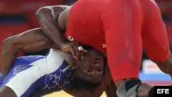 Archivo - El luchador cubano Livan Lopez Azcuy (rojo) se enfrenta al canadiense Haislan Veranes Garcia (azul) en Londres. 