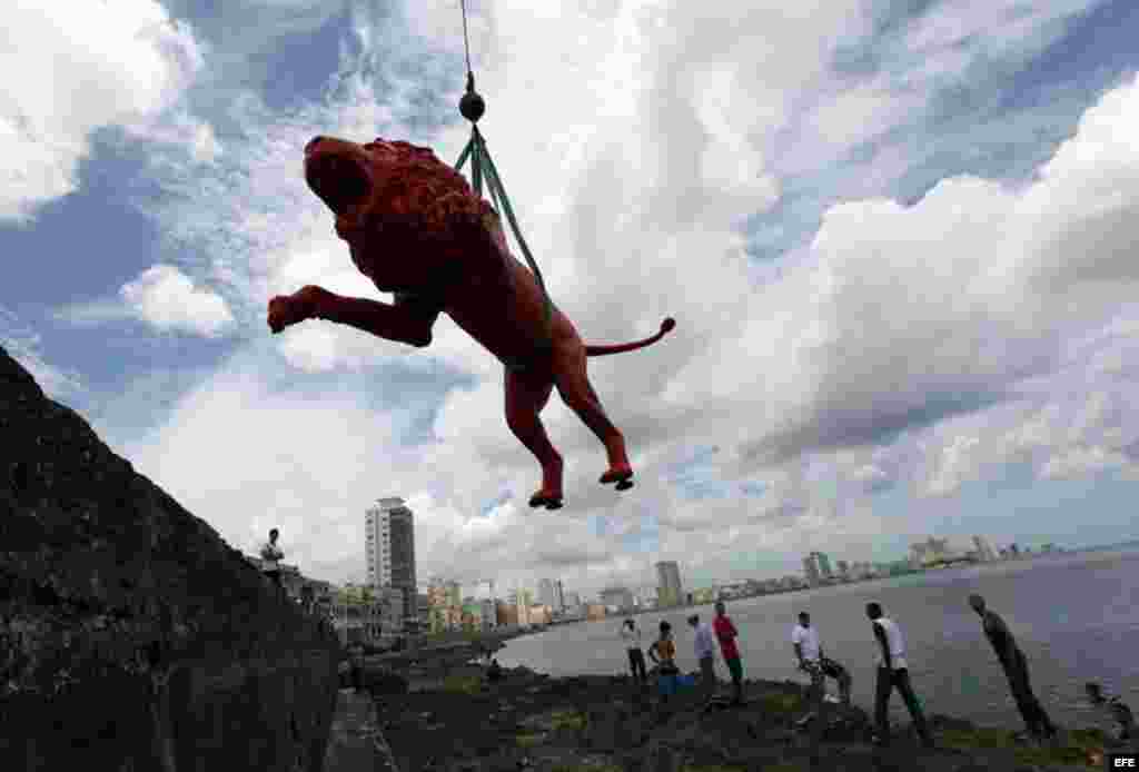 El artista pl&aacute;stico cubano Roberto Fabelo (i) posa junto a un le&oacute;n rojo creado por &eacute;l que conforma la obra "Garras en la piedra" que se instala en los arrecifes del malec&oacute;n de La Habana (Cuba). Esta pieza forma parte 