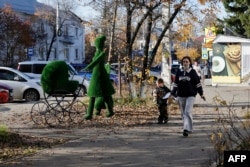 Una mujer y un niño caminan por una calle de la localidad de Shelejov, en la región de Irkutsk, el 7 de octubre de 2026.