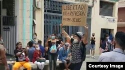 Joven con cartel protesta en el bulevar de San Rafael, La Habana