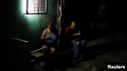 Los guardias de seguridad Eduardo Carbonell y Lubia Rodríguez cenan en su lugar de trabajo, en La Habana, Cuba, el 3 de agosto de 2026. REUTERS/Norlys Perez