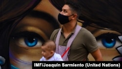 Un padre con su hijo durante la pandemia COVID en la comuna 13 de Medellin, en Colombia. IMF/Joaquín Sarmiento.