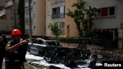 Equipos de emergencia trabajan junto a un vehículo destruido en un lugar de impacto, tras una andanada de misiles lanzados desde Irán, en medio del conflicto entre Estados Unidos e Israel con Irán, en el centro de Israel, el 4 de abril de 2026. REUTERS/Florion Goga