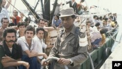 Un grupo de cubanos espera la salida de su bote del puerto de Mariel (Foto: AP/Jaques Langevin).