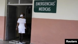 Enfermera cubana se desinfecta los zapatas a la entrada de un hospital en La Habana, Cuba. 