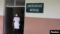 Enfermera cubana se desinfecta los zapatas a la entrada de un hospital en La Habana, Cuba. 