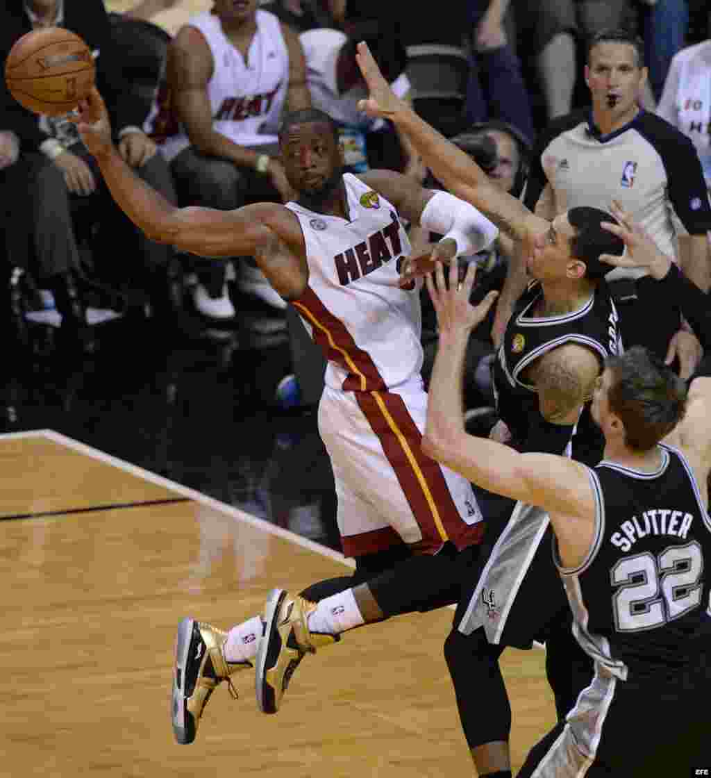 El jugador de Heat Dwyane Wade (i) pasa el balón ante la marca Tiago Splitter (d) y Danny Green (c), de Spurs. 