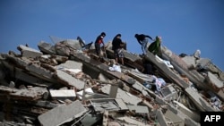 Residentes buscan entre los escombros de un edificio derrumbado tras los sismos, en Catia La Mar, La Guaira. (Federico Parra/AFP))