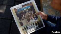 Un hombre sostiene un periódico que dice "Presidente Bukele" tras las elecciones presidenciales, en San Salvador, El Salvador, 5 de febrero de 2024. REUTERS/José Cabezas