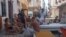Vecinos de Campanario y Neptuno se concentran en los bajos con sus pertenencias tras el derrumbe