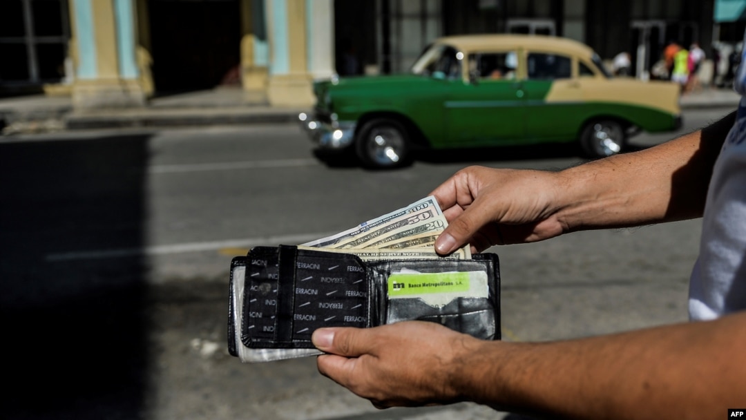 Un hombre muestra su cartera con dólares estadounidenses. (Yamil Lage/AFP/Archivo)