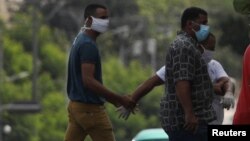 Un agente vestido de civil detiene el martes a un hombre en el lugar donde estaba previsto que se hiciera la protesta (Alexandre Meneghini/Reuters).