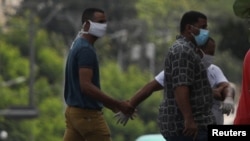 Un agente vestido de civil detiene el martes a un hombre en el lugar donde estaba previsto que se hiciera la protesta (Alexandre Meneghini/Reuters).