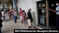 Cubanos esperan para entrar a una tienda MLC en La Habana.