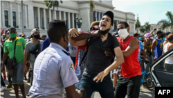 Un hombre es detenido el 11 de julio de 2021 frente al Capitolio de La Habana. Foto YAMIL LAGE AFP.