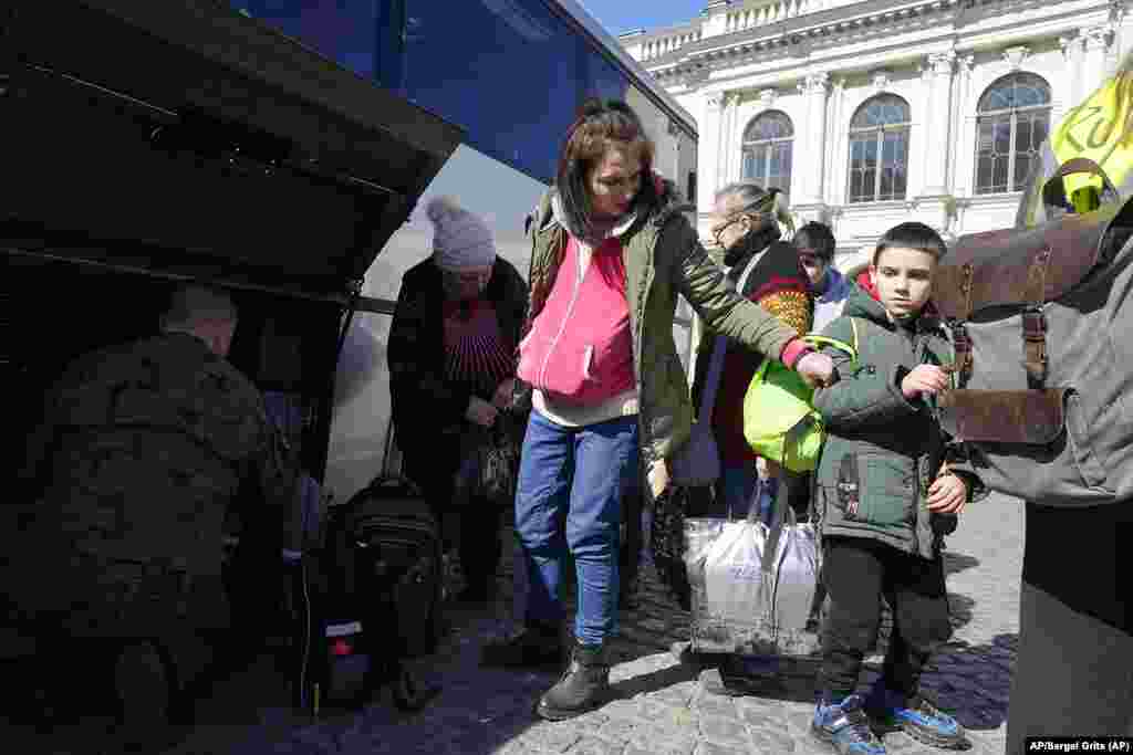 Refugiados ucranianos acompañados de niños se suben a un tren en una estación en Przemysl, Polonia. Foto: AP/Sergei Grits.