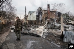 Un soldado ucraniano camina entre los restos de un avión derribado en Kiev, Ucrania,
