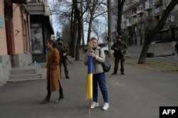 Mujer porta bandera de Ucrania en las proximidades del edidficio Asamblea Regional de Mykolaiv, Ucrania, bombardeado por los rusos