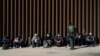 Migrantes de Venezuela y Cuba detenidos por la patrulla fronteriza de EEUU después de cruzar la frontera desde México en Yuma, Arizona el 17 de febrero de 2022.