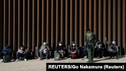 Migrantes de Venezuela y Cuba detenidos por la patrulla fronteriza de EEUU después de cruzar la frontera desde México en Yuma, Arizona el 17 de febrero de 2022. 